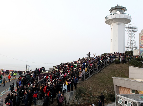 새해 육지에서 해가 가장 먼저 뜨는 울산 간절곶 해안위 간절곶 등대 앞에 해맞이객들이 해를 기다리며 줄지어 서 있다. (사진=저작권자(c) 연합뉴스, 무단 전재-재배포 금지)