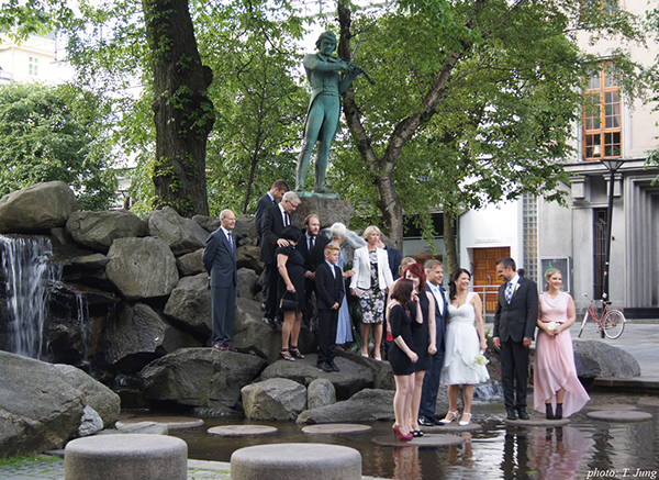 베르겐 중심가 울레 불 광장에서 울레 불 동상을 배경으로 결혼축하 사진 찍는 사람들.
