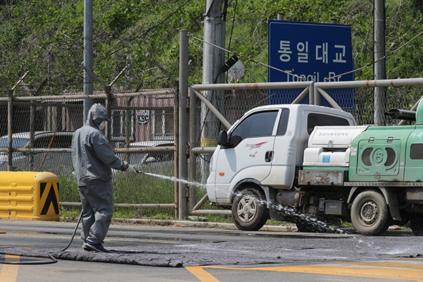 3일 경기도 파주시 통일대교 북단 민통선 지역에서 축산 방역당국이 도로에 방역 약품을 살포하고 있다.(사진=저작권자(c) 연합뉴스, 무단 전재-재배포 금지)