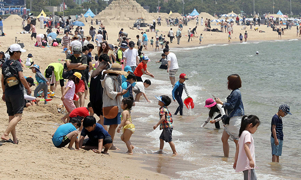 지난 1일 개장한 부산 해운대 해수욕장을 찾은 나들이객들이 해변에서 더위를 식히고 있다. (사진=저작권자(c) 연합뉴스, 무단 전재-재배포 금지)