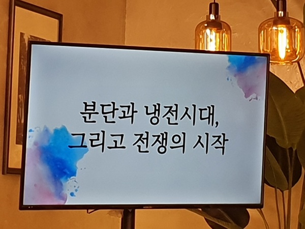 강연 도중 모니터에서는 분단과 냉전시대 그리고 전쟁의 시작을 알리고 있다.