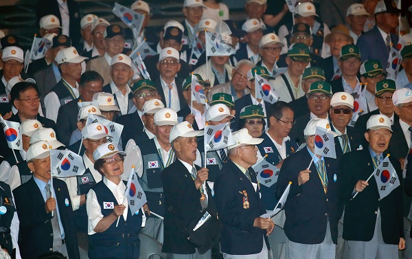 25일 서울 중구 장충체육관에서 열린 6·25 전쟁 69주년 기념 행사에 참석한 6·25 참전 유공자들이 태극기를 흔들며 6·25의 노래를 부르고 있다. (사진=저작권자(c) 연합뉴스, 무단 전재-재배포 금지)