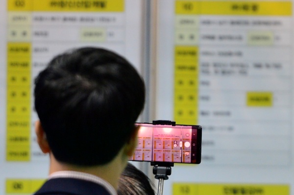 11일 오후 경북 포항시 포항실내체육관에서 열린 2019 구인구직 취업연계박람회를 찾은 구직자들이 채용공고 개시판에 나와 있는 일자리를 확인하고 있다.