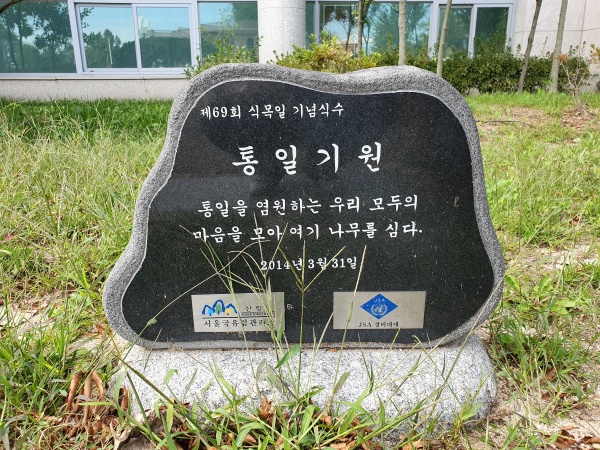 JSA 안보교육관 앞 화단에 통일을 염원하는 마음을 모아 나무를 심었다는 기념비가 세워져 있다.