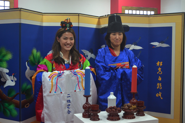 부산을 찾은 일본인 관광객이 전통 혼례복을 입어보고 기념사진을 임하고 있다.