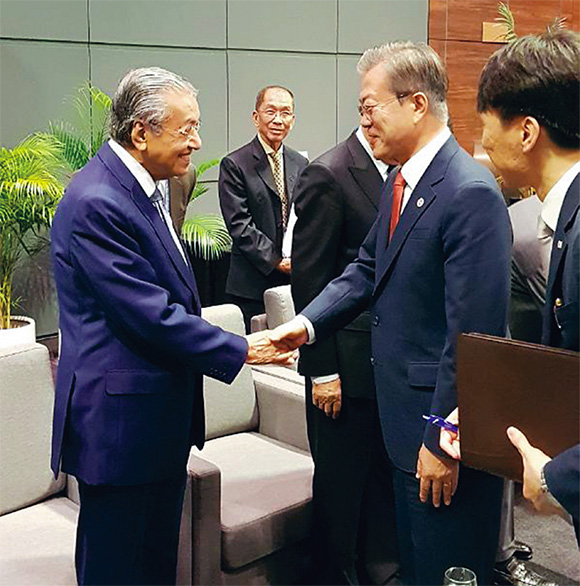 문재인 대통령이 2018년 11월 파푸아뉴기니에서 열린 아세안(ASEAN) 정상회의에서 마하티르 모하맛 말레이시아 총리와 악수하고 있다.│청와대사진기자단