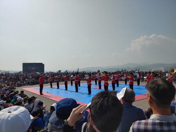많은 관객이 군악대의 공연을 관람하고 있다.