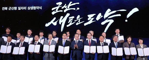 문재인 대통령이 24일 오후 전북 군산 명신 공장에서 열린 '군산형 일자리 상생협약식'에서 관계자들과 기념촬영을 하고 있다. 전북 군산형 일자리는 명신그룹이 주축이 된 '명신 컨소시엄'과 에디슨모터스, 대창모터스, MPS코리아가 중심이 된 '새만금 컨소시엄' 등 2개 컨소시엄으로 진행된다. (저작권자(c) 연합뉴스, 무단 전재-재배포 금지)