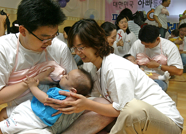 아빠들이 아이를 안고 분유만 먹여도 옥시토신 분비는 높아진다. 사진은 아빠들이 수유브래지어를 착용하고 아기에게 젖을 먹이고 있는 모습. (사진=저작권자(c) 연합뉴스, 무단 전재-재배포 금지)