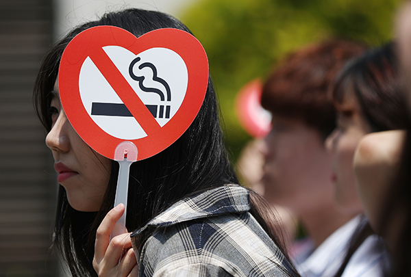 세계금연의 날인 5월 31일 오후 서울 종로구 세종로공원에서 열린 기념식에서 한 참석자가 금연 로고가 새겨진 부채로 햇볕을 가리고 있다. (사진=저작권자(c) 연합뉴스, 무단 전재-재배포 금지)