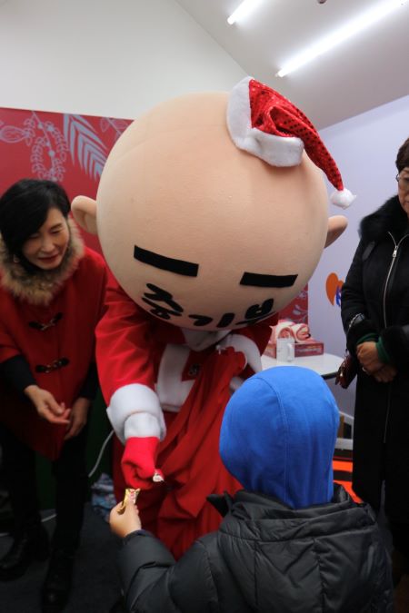 크리스마스마켓에서 몰래산타에게 초콜릿 선물을 받고 있는 아이.