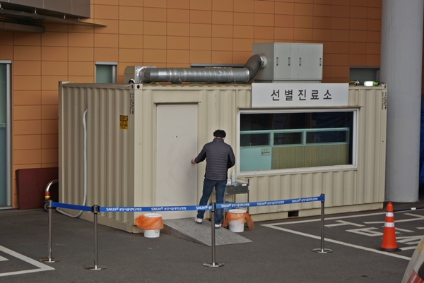 야외에 설치된 선별진료소에 한 시민이 검진을 위해 들어가고 있다.