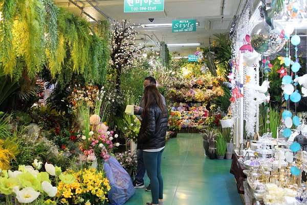 고속버스터미널 꽃 도매시장에서 사장님과 손님이 이야기하고 있다.