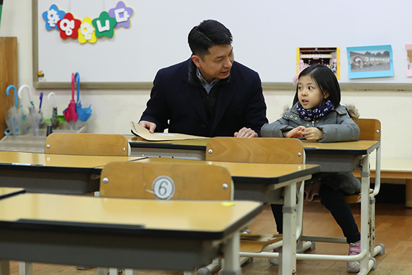 서울 공립초등학교 신입생 예비소집일인 8일 서울 용산초등학교를 찾은 한 예비초등생이 1학년 교실 의자에 앉아 아빠와 대화하고 있다. (사진=저작권자(c) 연합뉴스, 무단 전재-재배포 금지)