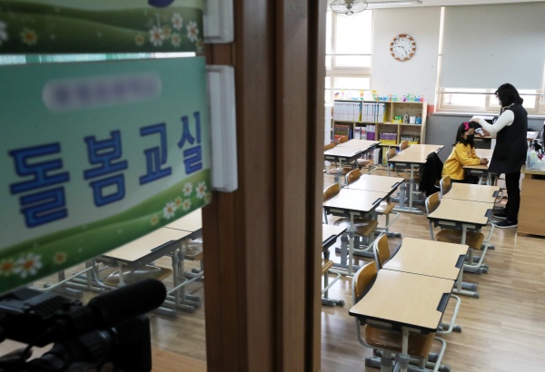 2일 오전 경기도 수원시 한 초등학교에서 신종 코로나바이러스 감염증(코로나19) 확산에 따른 개학 연기로 운영되는 긴급돌봄교실 신청 학생들이 마스크를 쓴 채 발열 검사를 받고 있다.