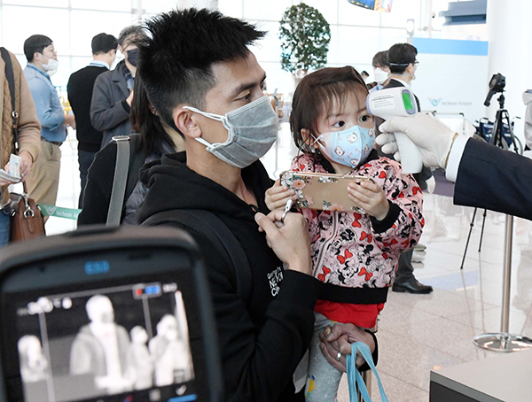 지난달 28일 인천국제공항 2터미널 인천발 로스앤젤레스(LA)행 탑승구 앞에서 대한항공 직원들이 탑승 승객의 발열 여부를 확인하고 있다. (사진=저작권자(c) 연합뉴스, 무단 전재-재배포 금지)