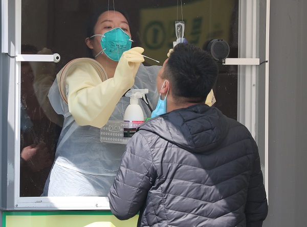 3일 오후 서울 송파구 잠실종합운동장에 마련된 워크스루 방식 선별진료소에서 한 시민이 검체채취를 받고 있다.서울시는 3일부터 서울 거주 입국자들에 대해 전원 검사를 실시한다. 서울 거주 입국자는 공항에서 발열 체크를 거친 뒤 유증상자는 인천공항 선별진료소에서, 무증상자들은 잠실종합운동장에 마련된 해외입국자 전용 워크스루 선별진료소 또는 해당보건소에서 진단검사를 받는다. (사진=저작권자(c) 연합뉴스, 무단 전재-재배포 금지)