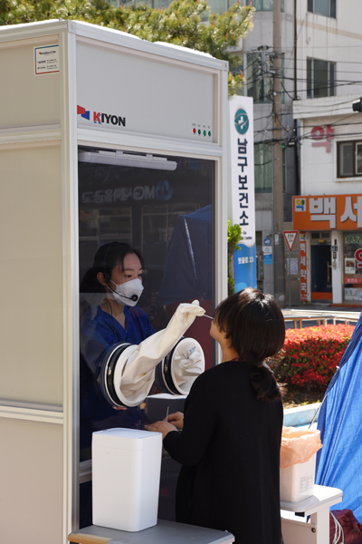 부산 남구보건소 안여현 의무사무관(의사)이 만든 초스피드 워킹스루 검사부스에서 코로나19 검사를 하고 있다.