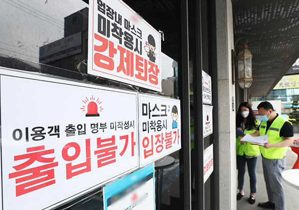 11일 오후 경기도 수원시의 한 클럽에서 공무원들이 코로나19 확산 방지를 위한 집합금지 행정명령서를 붙이고 있다. (사진=저작권자(c) 연합뉴스, 무단 전재-재배포 금지)