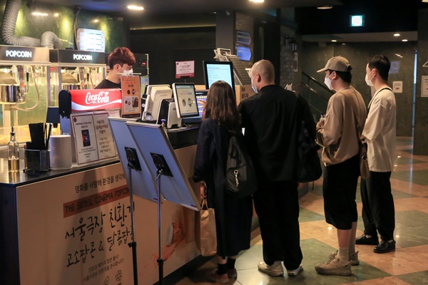 명부를 작성하고 표를 구매하는 관객들