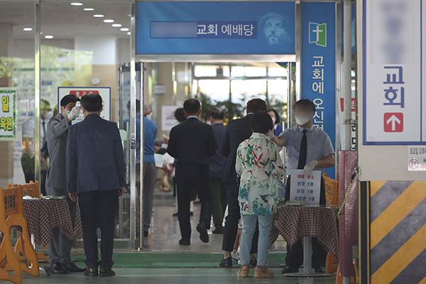 5일 오전 광주 북구 한 교회에서 관계자가 예배에 참석하려는 신도의 체온을 확인하고 있다. 광주시와 각 자치구는 코로나19 확산에 따른 사회적 거리두기 2단계 격상으로 종교시설 방역지침 준수 여부를 점검했다. (사진=저작권자(c) 연합뉴스, 무단 전재-재배포 금지)