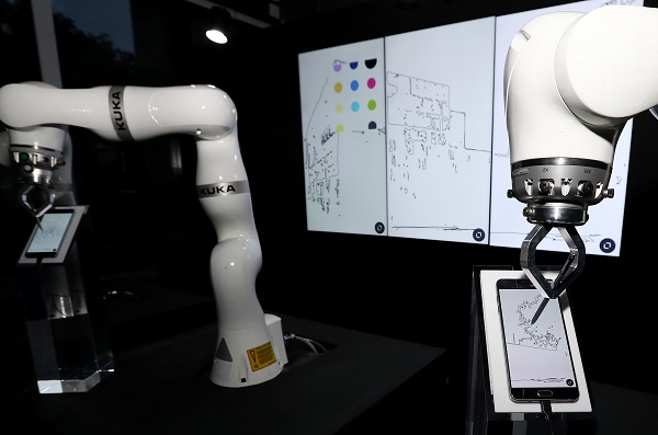 코로나19이후 산업 현장에는 스마트팩토리를 구축해 생산성을 향상시키려는 움직임이 일고 있다. 사진은 휴대전화에 그림을 그리는 로봇 모습. ( 저작권자(c) 연합뉴스, 무단 전재-재배포 금지) 