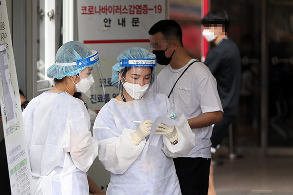 지난달 21일 오전 광주 동구 전남대병원 선별진료소에서 의료진이 중국인 유학생 등 방문객이 작성한 코로나19 진단검사 신청서를 확인하고 있다. (사진=저작권자(c) 연합뉴스, 무단 전재-재배포 금지)