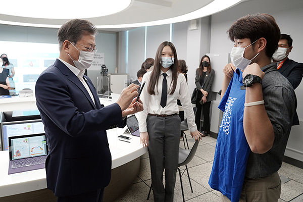 문재인 대통령이 8월 18일 오전 ‘한국판 뉴딜, 현장에 가다’의 일환으로 그린 스마트 교육을 시행 중인 서울 중구 창덕여자중학교를 방문, 스마트 수업 시연에 참여해 안영석 수학교사가 든 티셔츠를 스마트폰으로 촬영하고 있다. (사진=청와대)