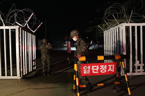 25일 경기도 연천군 육군 모부대 신병교육대대에서 위병소 장병이 방역당국 관계자들을 부대에 들여 보낸 뒤 출입문을 닫고 있다. (사진=저작권자(c) 연합뉴스, 무단 전재-재배포 금지)