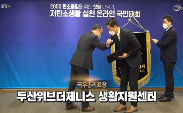 탄소중립에 기여한 기관과 단체에 대한 시상식이 진행됐다. 방역을 준수하며 팔꿈치로 악수하는 모습(출처=저탄소생활 온라인 국민운동 캡처)