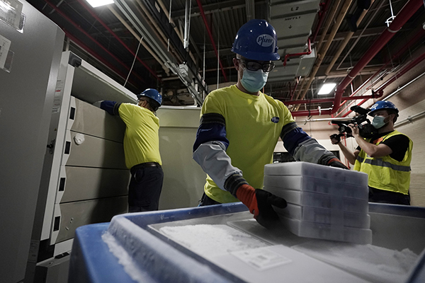 미국 미시간주 포티지에 있는 화이자 공장에서 13일(현지시간) 직원들이 화이자·바이오앤테크의 코로나19 백신 상자를 운송용기에 싣고 있다. (사진=저작권자(c) 포티지 EPA/AP=연합뉴스, 무단 전재-재배포 금지)