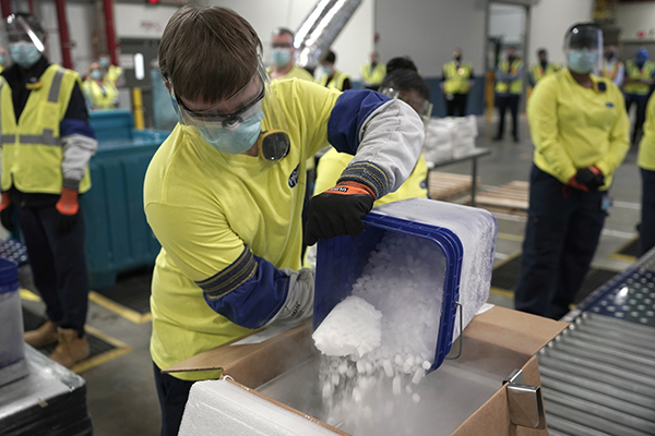 미국 미시간주 포티지의 화이자 제약공장에서 직원들이 코로나19 백신 운송 상자에 드라이아이스를 넣고 있다.