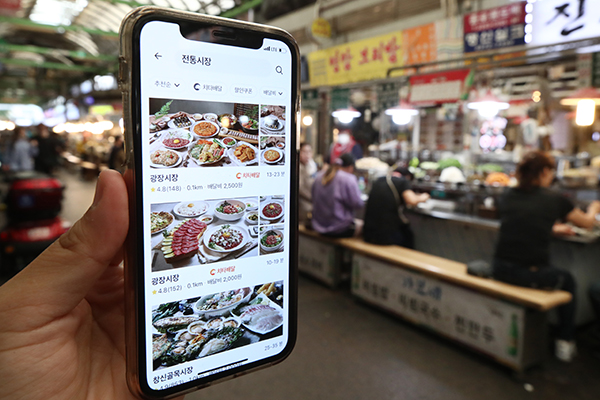 서울 광장시장에서 앱을 통해 전통시장 배달 서비스를 이용하는 모습.