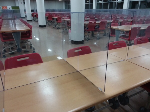 학교 급식실에 투명 칸막이가 설치되어 있다.