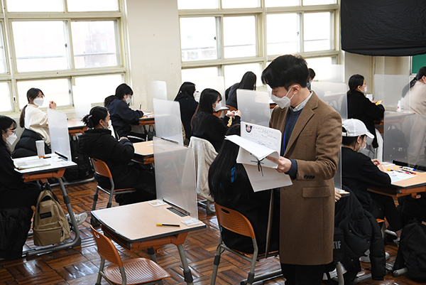 지난해 대학수학능력시험일인 12월 3일 오전 부산 동구 경남여고의 한 시험장에서 감독관들이 수험생 신원을 확인하고 있다.