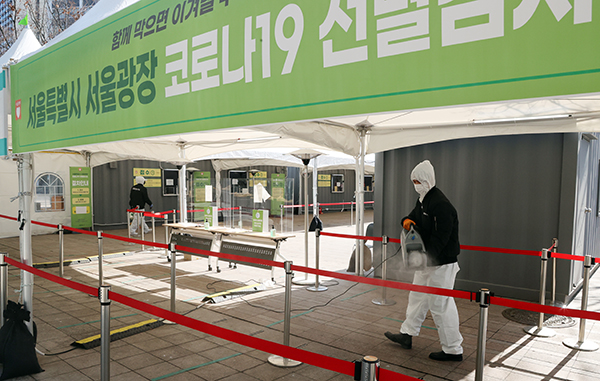 서울시청 앞 선별검사소에서 관계자들이 잠시 검사를 중지하고 시설물 정기방역을 하고 있다.