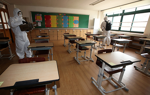 광주 서구 금당초등학교에서 방역요원이 코로나19 예방을 위해 교실을 방역하고 있다.