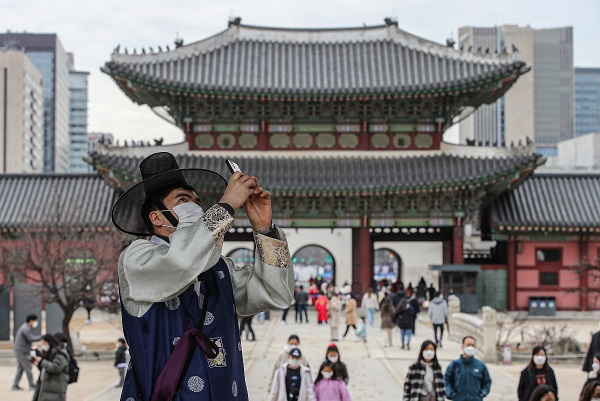 삼일절 연휴인 2월 28일 오후 서울 종로구 경복궁을 찾은 한 외국인이 한복에 마스크를 쓰고 궁 건축물을 휴대전화로 찍고 있다.(사진=저작권자(c) 연합뉴스, 무단 전재-재배포 금지)