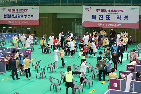 광주 북구 예방접종센터에서 75세 이상 어르신들이 북구청 공무원과 자원봉사자들의 도움을 받아 이동하고 있다.