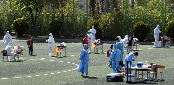 지난 19일 광주의 한 초등학교 운동장에 신종 코로나바이러스 감염증(코로나19) 임시 선별진료소가 마련돼 재학생이 전수 검사에 참여하고 있는 모습. (사진=저작권자(c) 연합뉴스, 무단 전재-재배포 금지)