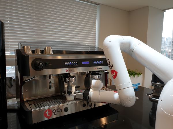 바리스타 로봇이 내가 주문한 커피를 만들고 있다.