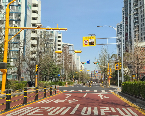 어린이 보호구역은 노란색 신호등과 암적색 포장으로 운전자들이 쉽게 식별할 수 있다.