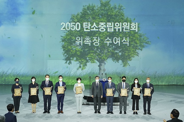 문재인 대통령이 29일 오후 서울 동대문디자인플라자에서 열린 ‘2050 탄소중립위원회 출범식’에 참석해 윤순진 민간위원장을 비롯한 위원들에게 위촉장 수여 후 기념촬영을 하고 있다.(사진=청와대)