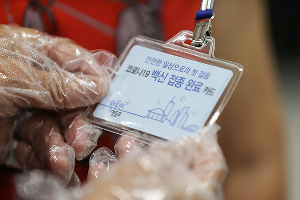 17일 오전 서울 영등포구 영등포아트홀에 마련된 코로나19 예방접종센터에서 한 어르신이 백신 접종 완료 카드를 보고 있다.