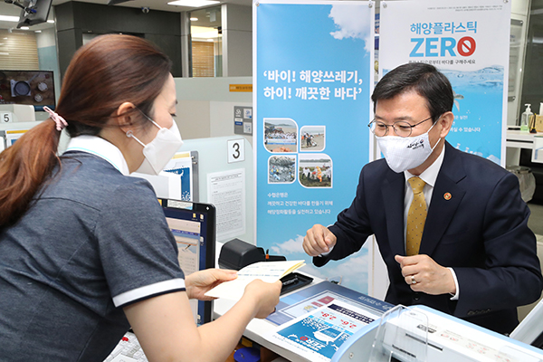 문성혁 해양수산부 장관이 해양쓰레기 저감활동을 지원하는 금융상품인 ‘해양플라스틱제로 예금&적금’에 가입하기 위해 지난해 5월 세종시 수협은행을 방문해 통장을 만들고 있다.(사진=저작권자(c) 연합뉴스, 무단 전재-재배포 금지)