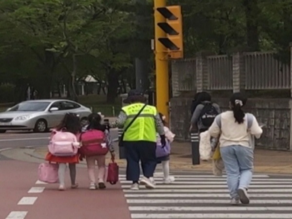 한 초등학교 앞에서 교통 봉사를 하시는 어르신