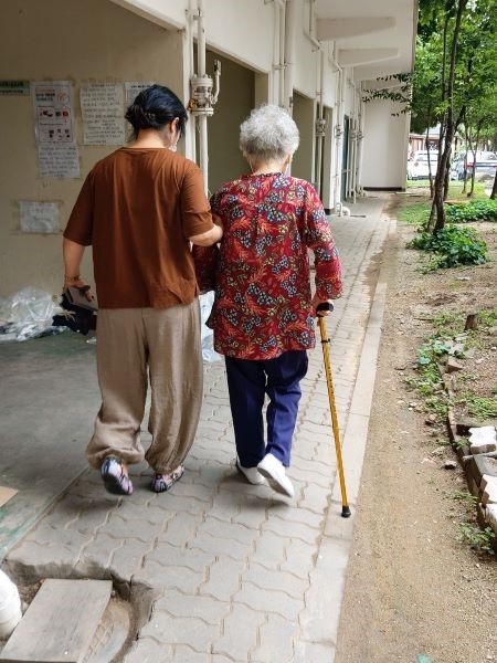 어르신이 요양보호사의 부축을 받으며 동네를 산책하고 있다.(사진=서울시사회서비스원 성동종합재가센터)