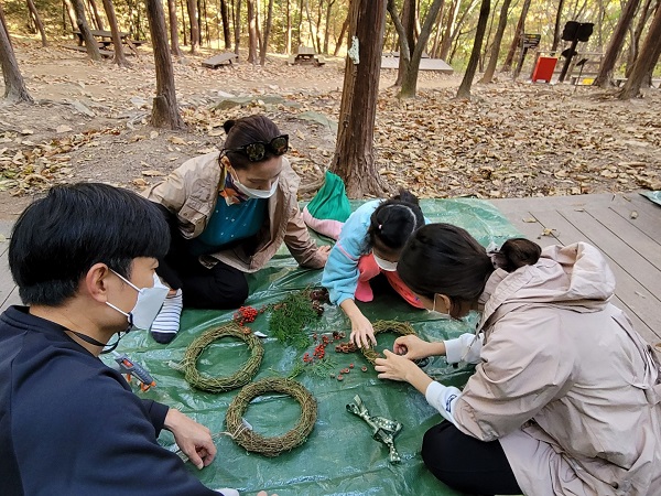 편백 나뭇잎과 솔방울 등 자연물을 활용한 솔방울 리스 만들기 체험 모습. (사진=한국관광공사 부산울산지사)