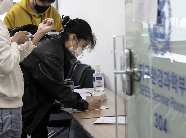 서울대가 대면 수업 기조로 전환한 첫날인 10월 18일 학생들이 수업에 앞서 체온을 확인하고 문진표를 작성하고 있다. (사진=저작권자(c) 연합뉴스, 무단 전재-재배포 금지)