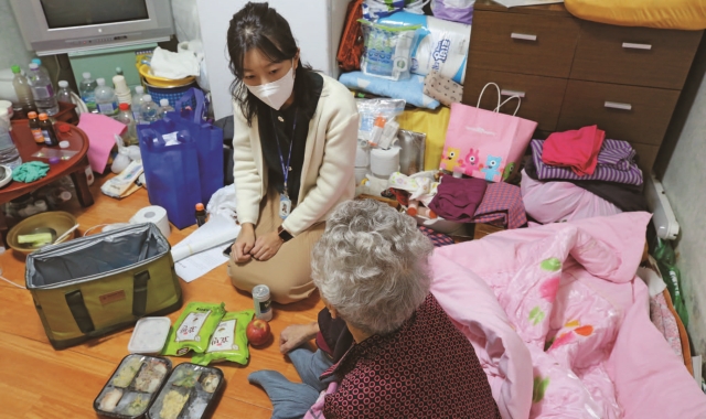 ▶서울의 한 보건소 영양사가 홀로 사는 어르신에게 맞춤형 영양간편식을 전달하고 있다. (사진=한겨레)